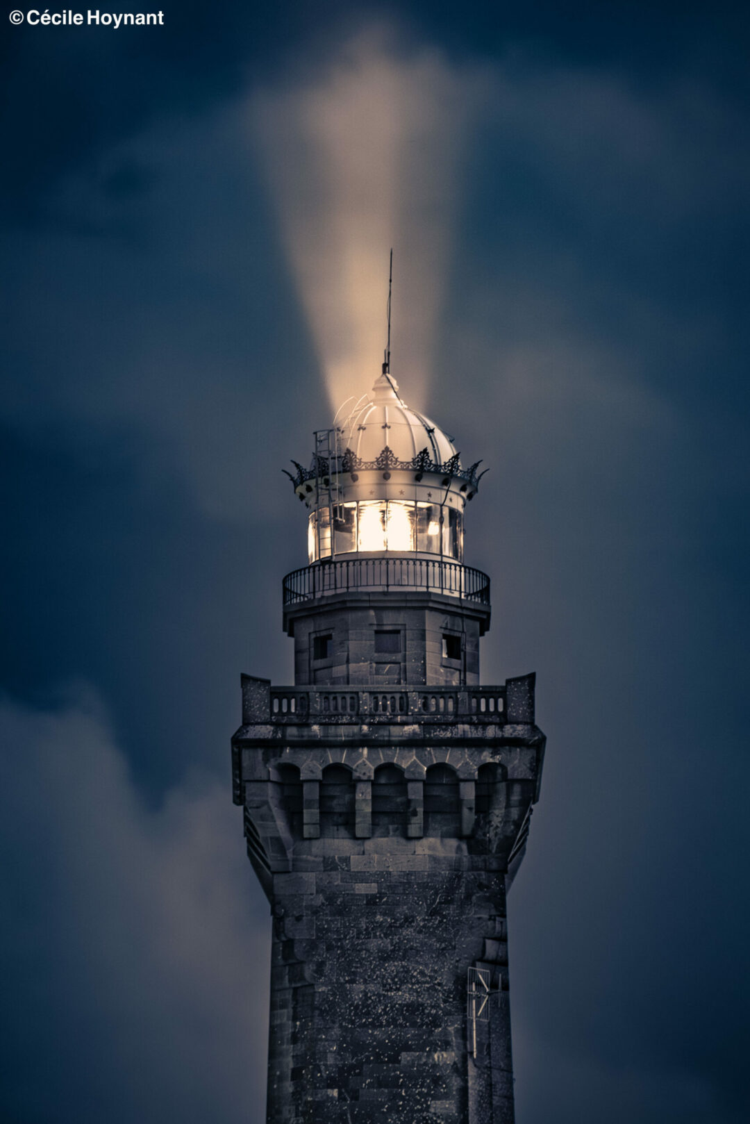 Faisceau du Phare d'Eckmühl à la pointe de Penmarc'h dans le Finistère Sud en Bretagne éclairant la nuit. Nuages visibles dans le bleu métallique de la nuit.