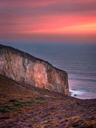Tirage d'art des falaises de la Presqu'île de Crozon en Bretagne au coucher du soleil, tapis de bruyère et d'ajoncs en fleurs.