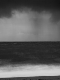 Photo d'art en tirage limité, numéroté et signé, noir et blanc, pose longue, paysage de tempête en Bretagne avec la lumière des phares à l'horizon.