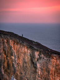 Photo d'art, tirage numéroté et signé en série limitée, silhouette contemplant un sublime coucher du soleil du haut d'une falaise de la presqu'île de Crozon, au Cap de la Chèvre, Bretagne.