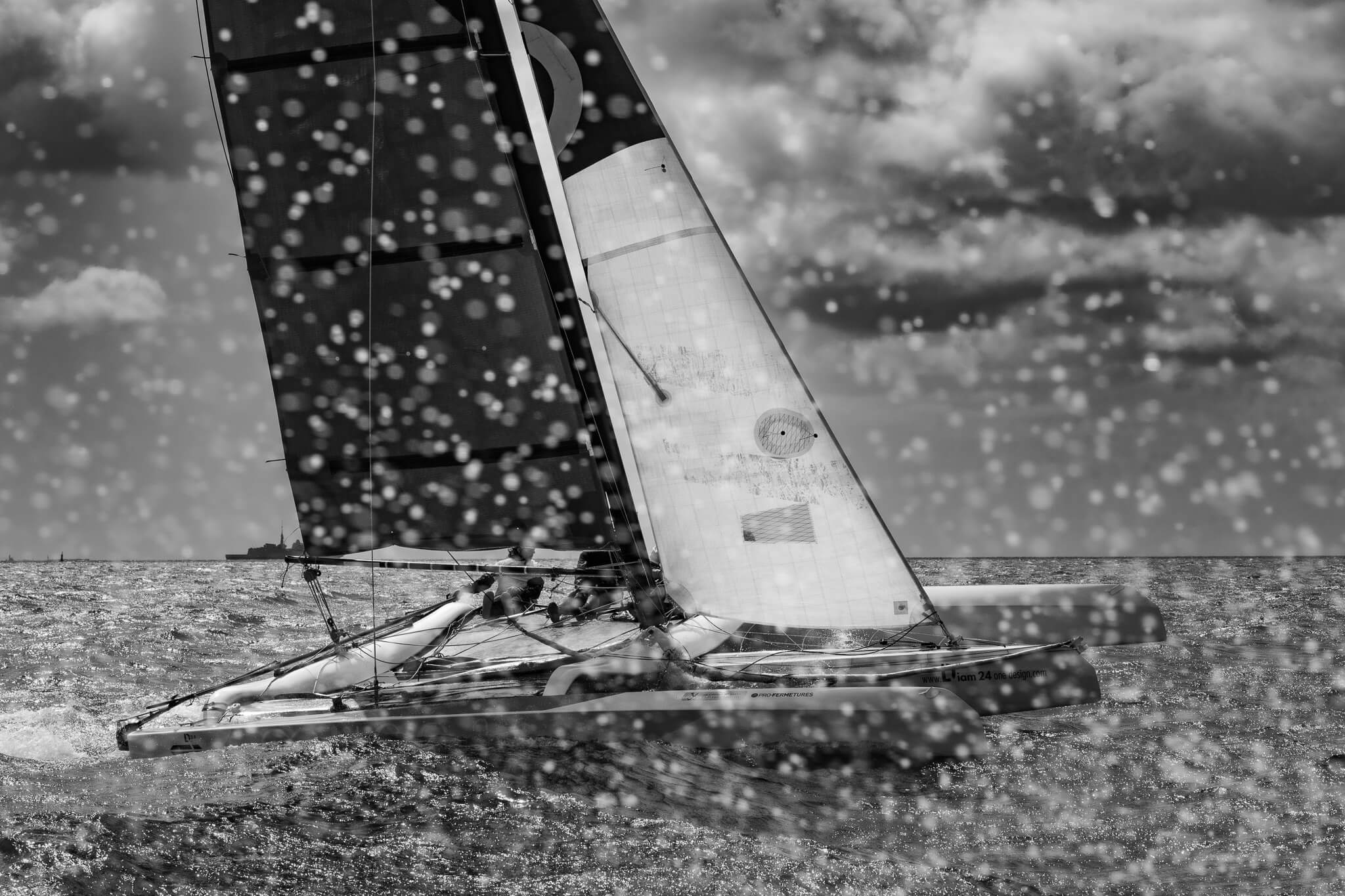 Trimaran Diam 24 dans un nuage d'embruns lors d'une banque d'images pour Mer Concept, l'écurie de course au large de François Gabart.