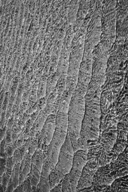 Tirage d'art d'une photo en noir et blanc, en série limitée, numéroté et signé. Fine pellicule d'eau de mer sur une plage de sable formant une superbe mosaïque.
